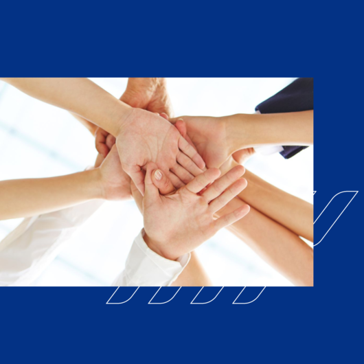 Several people’s hands stacked together, symbolizing teamwork and collaboration.