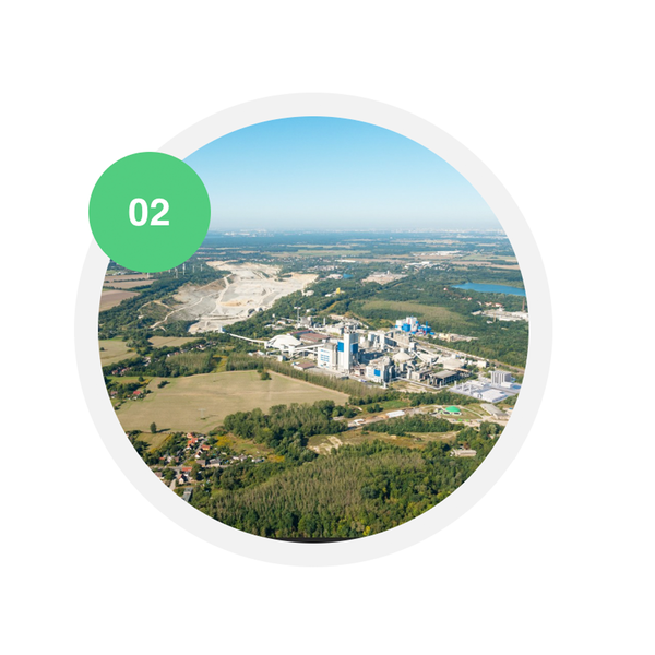 Luftaufnahme des Zementwerks Rüdersdorf mit angrenzendem Kalksteinbruch und umliegender Landschaft. Ein grüner Kreis mit der Zahl „02“ markiert den Schritt der CO₂-Abscheidung im Produktionsprozess.